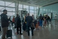 People with mask wait in a line in front of flight gate and air personnel check their temperature in Aydin Menderes Airport