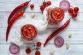 Gazpacho soup ingredients - three hot red chili peppers, onion rings, garlic and small cherry tomatoes decorated with white cloth Royalty Free Stock Photo