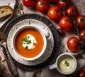 Gazpacho tomato soup in a bowl with cream in a country style, flatlay of a serving and products for the recipe, comfort