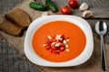 Gazpacho tomato soup in a white bowl spoon on a towel on the background of wooden boards Royalty Free Stock Photo