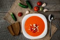 Gazpacho tomato soup in a white bowl spoon on a towel on the background of wooden boards Royalty Free Stock Photo