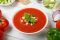 Traditional Spanish tomato soup Gazpacho with fresh tomatoes, cucumber, bell pepper and basil on a white rustic wooden table. Royalty Free Stock Photo