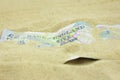 GBP Five Pound note covered in sand Royalty Free Stock Photo