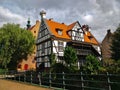 Old historical house on the edge of the Gdansk city center with white facade with wooden beams and red roof