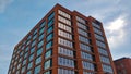 Red brick office building with big windows reflecting the surrounding sky Royalty Free Stock Photo