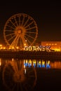 Gdansk Poland March 2022 Ferris wheel in the old town of Gdansk at night Reflection Blue and yellow colors of Ukrainian