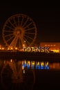 Gdansk Poland March 2022 Ferris wheel in the old town of Gdansk at night Reflection Blue and yellow colors of Ukrainian