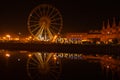 Gdansk Poland March 2022 Ferris wheel in the old town of Gdansk at night Reflection Blue and yellow colors of Ukrainian