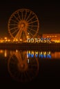 Gdansk Poland March 2022 Ferris wheel in the old town of Gdansk at night Reflection Blue and yellow colors of Ukrainian