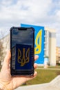 Gdansk Poland March 2022 UKRAINE national emblem with pigeon symbol of peace IN GRAFFITI throw mobile phone. Taking