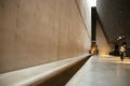 Gdansk, Poland - November 19, 2017:A girl is sitting at the end of a long bench in the museum of the Second World War