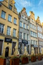 Old street with historic, colorful buildings and different establishments in Gdansk, Poland