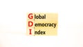 GDI global democracy index symbol. Concept words GDI global democracy index on wooden blocks on a beautiful white table white