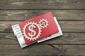 Gear, dollars, book on a wooden background.