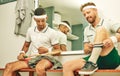 Gear up, its gonna be a good game. two young men getting dressed in the locker room after a game of squash. Royalty Free Stock Photo