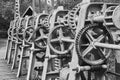 Gear wheels, toothed belts, chains, shafts and racks at a weir on the river Aller, Germany, black and white