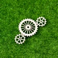 Gears made of wood on the background of artificial green grass.