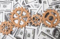 Gears made of wood on the background of dollar bills. Royalty Free Stock Photo