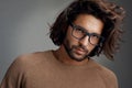 Geek chic. Studio shot of a handsome young man wearing glasses against a gray background. Royalty Free Stock Photo