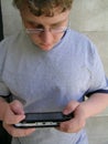 Geek with portable game device Royalty Free Stock Photo
