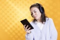 Geek reading digital novel on tablet screen and hearing songs, studio background Royalty Free Stock Photo