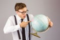 Geeky businessman pointing to globe Royalty Free Stock Photo