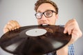 Geeky hipster biting vinyl record Royalty Free Stock Photo