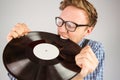 Geeky hipster biting vinyl record Royalty Free Stock Photo