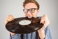 Geeky hipster biting vinyl record Royalty Free Stock Photo