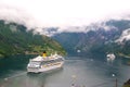 Geiranger, Norway - January 25, 2010: travel destination, tourism. Cruise ship in norwegian fjord. Passenger liner docked in port. Royalty Free Stock Photo