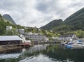 Geiranger, Norway, September 7, 2019: View on Geiranger tourist village harbor with small boats, hotel and port pier Royalty Free Stock Photo