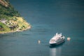 Geirangerfjord, Norway. Touristic Ship Ferry Boat Floating Liner Moored Near Geiranger In Geirangerfjorden In Spring