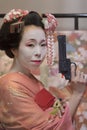 Geisha girl in kimono holding a plastic gun in her hand. Royalty Free Stock Photo