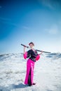 Geisha with katana in black and pink kimomo on winter landscape and blue sky background. Royalty Free Stock Photo