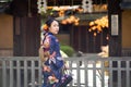 Geishas girl wearing Japanese kimono among red wooden Tori Gate at Fushimi Inari Shrine in Kyoto, Kimono is a Japanese traditional Royalty Free Stock Photo