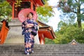 Geishas girl wearing Japanese kimono among red wooden Tori Gate at Fushimi Inari Shrine in Kyoto, Kimono is a Japanese traditional Royalty Free Stock Photo