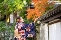 Geishas girl wearing Japanese kimono among red wooden Tori Gate at Fushimi Inari Shrine in Kyoto, Kimono is a Japanese traditional Royalty Free Stock Photo