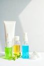 Gel green and blue, yellow oil for face care in glass bottles. Jar of cream and a white tube. leaves and flowers. Vertical photo Royalty Free Stock Photo