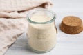 Gelatin powder in glass jar on white wooden table, closeup