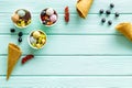 Gelato, waffle cone, berries, chocolate, on mint green wooden background top view copyspace