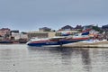 The russian multipurpose amphibian aircraft Beriev Be-200ES gathers water and is preparing to take off from the smooth surface