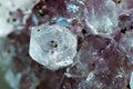 Gemstone Amethyst closeup as a part of cluster geode filled with rock Quartz crystals.