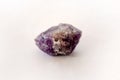 Macro shooting of raw Amethyst stone isolated on white background. Purple raw gem stone. Royalty Free Stock Photo