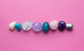 Gemstone minerals on a pink background. Round tumbling minerals of amethyst, rose quartz, apatite, turquoise, agate