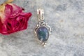 gemstone pendant in silver metal decorative oval on natural backhround