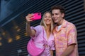 Gen Z couple in pink outfit taking selfie before going the cinema to watch movie. Royalty Free Stock Photo