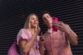 Gen Z couple in pink outfit taking selfie before going the cinema to watch movie. Royalty Free Stock Photo