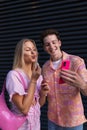 Gen Z couple in pink outfit taking selfie before going the cinema to watch movie. Royalty Free Stock Photo