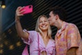 Gen Z couple in pink outfit taking selfie before going the cinema to watch movie. Royalty Free Stock Photo