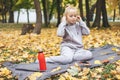 Gen z teenage girl using smartphote outdoors in autumn time.